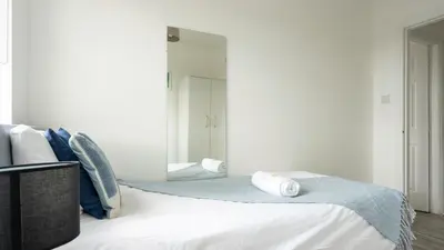 a bedroom with a bed with a large mirror at Ferguson House in Airdrie