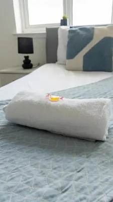 a white blanket sitting on top of a bed at Ferguson House in Airdrie