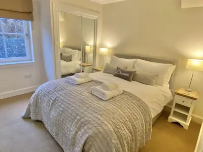 a bedroom with a bed with two towels on it at Brodie Cottage in Killin