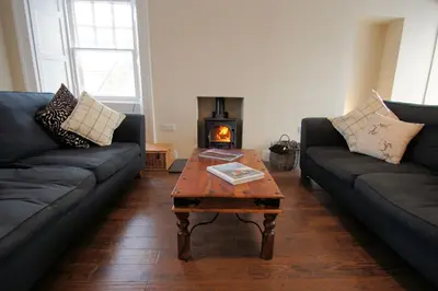a living room with two couches and a coffee table at Comrie Old Schoolhouse in Comrie