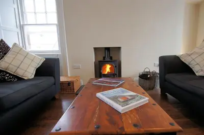 a living room with a wooden coffee table and a fireplace at Comrie Old Schoolhouse in Comrie