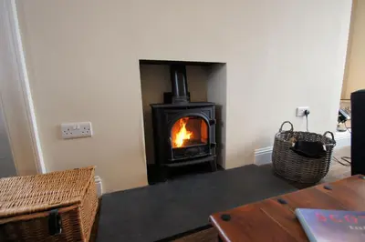 a living room with a wood stove in a room at Comrie Old Schoolhouse in Comrie