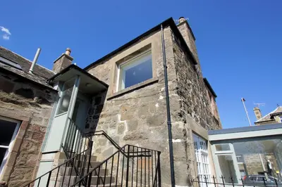 an old brick building with a window and a door at Comrie Old Schoolhouse in Comrie