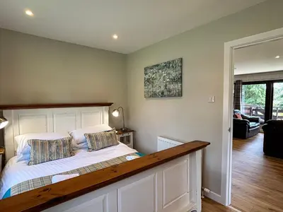 a bedroom with a bed with a wooden headboard at Bluebell Lodge 11 with Hot Tub in Newton Stewart