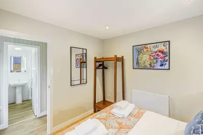 a bedroom with a bed and a mirror and a sink at Birch Lodge 13 with Hot Tub in Newton Stewart