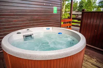 a jacuzzi tub sitting on a wooden deck at Birch Lodge 13 with Hot Tub in Newton Stewart