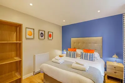 a bedroom with a large bed with blue walls at Birch Lodge 21 with Hot Tub in Newton Stewart