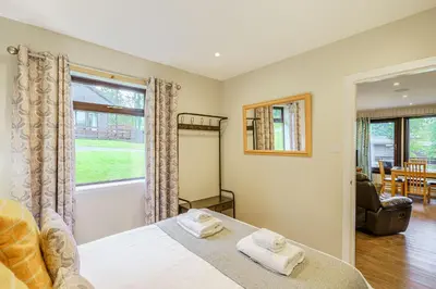 a bedroom with a bed and a window at Birch Lodge 16 in Newton Stewart