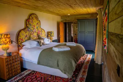 a bedroom with a large bed with a large headboard at The Artist's House at Jupiter Artland in Kirknewton