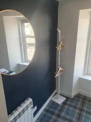 a dressing room with a mirror and a radiator at The Creek-Stone Den in Oban