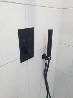 a black phone on a wall in a bathroom at The Creek-Stone Den in Oban