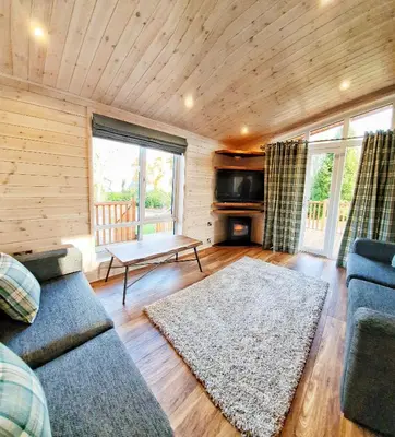 a living room with a couch and a table at Skyline Lodge Loch Lomond Castle Lodges in Balloch