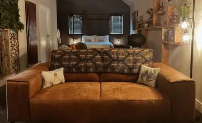 a brown leather couch in a living room at The Bothy in Stirling