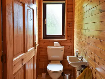 a bathroom with a toilet and a sink at Catkin Lodge - Uk39646 in Lunga
