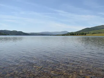 a large body of water with mountains in the background at Birch - Apartment in Aberfoyle