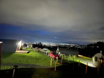 a red car parked on a grass field at night at Badger's Sett in Bathgate