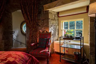 a bedroom with a bed and a chair and a window at Craigiehall Temple in Edinburgh