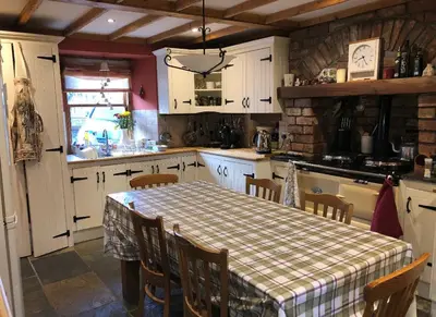 a kitchen with a table with a checkered table cloth at Karibu Cottage near the airport in Edinburgh