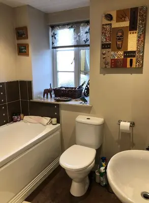 a bathroom with a white toilet and a sink at Karibu Cottage near the airport in Edinburgh