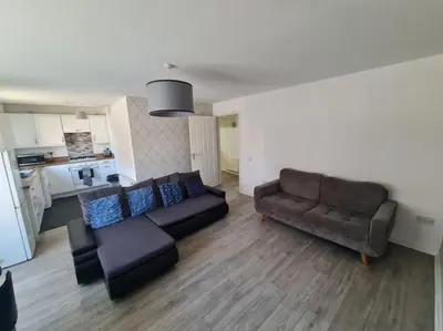 a living room with a couch and a chair at City, Celtic park & Emirates Stadium Apartment, for families or age over 23 in Glasgow