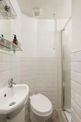 a white bathroom with a toilet and a sink at The Stockbridge Snug by Calton Living in Edinburgh