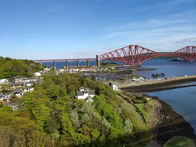 a red bridge over a river next to a body of water at Chilowen - Happy House in Inverkeithing