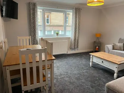 a living room with a table and a couch at Breadalbane Apartment in Oban