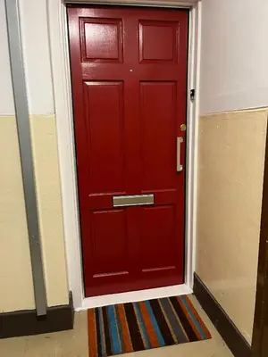 a red door with a rug in front of it at Breadalbane Apartment in Oban
