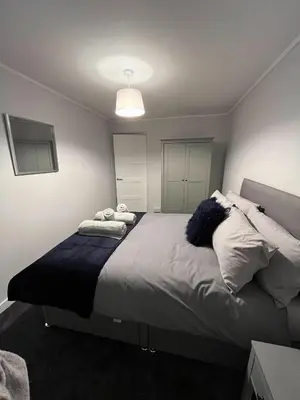 a bedroom with a large bed with pillows on it at Breadalbane Apartment in Oban