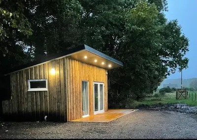 a small wooden building with lights on it at Cruachan Cabin in Oban