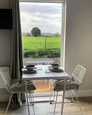 a table and chairs with a view of a field at Cruachan Cabin in Oban
