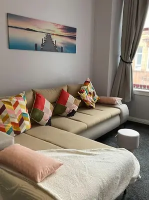 a living room with a couch and a window at Spacious one bedroom flat, entire property. in Greenock