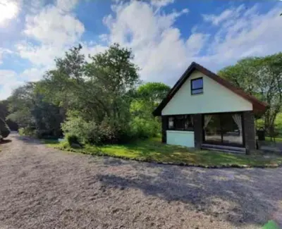 a small house on a gravel road at The Singing Heart, TirNaNog Cozy Cottage near Lochgilphead !!HIDDEN GEM!! in Lochgilphead