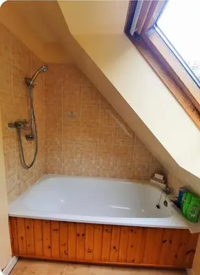 a bathroom with a bath tub in a attic at The Singing Heart, TirNaNog Cozy Cottage near Lochgilphead !!HIDDEN GEM!! in Lochgilphead