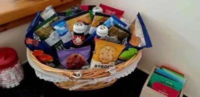 a basket filled with snacks on top of a table at The Singing Heart, TirNaNog Cozy Cottage near Lochgilphead !!HIDDEN GEM!! in Lochgilphead