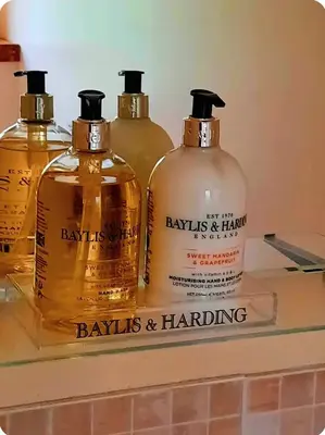 three bottles of whisky sitting on a shelf at The Singing Heart, TirNaNog Cozy Cottage near Lochgilphead !!HIDDEN GEM!! in Lochgilphead