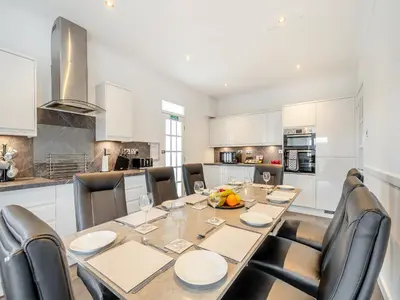 a kitchen with a dining room table and chairs at Kerrytonlia Cottage in Mountstuart