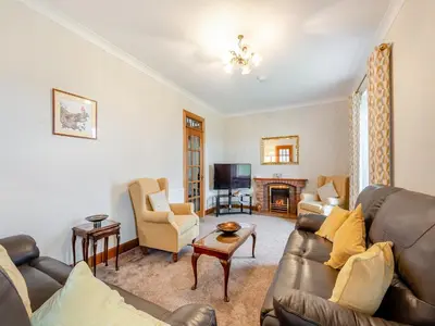 a living room with a couch and a tv at Kerrytonlia Cottage in Mountstuart