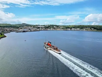a large boat traveling down a large body of water at Kerrytonlia Cottage in Mountstuart