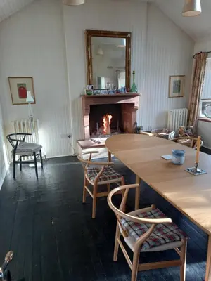 a living room with a fireplace and a table and chairs at Riverside House in Thornhill