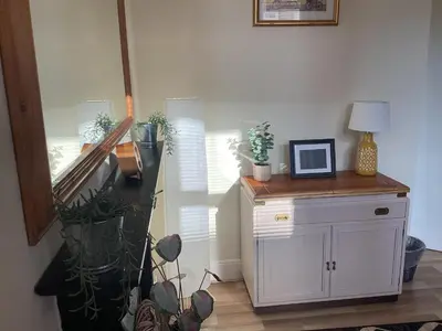 a room with plants and a table with a picture on it at Hillview, Ground floor apartment, Largs in Largs