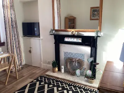 a living room with a fireplace and a television at Hillview, Ground floor apartment, Largs in Largs