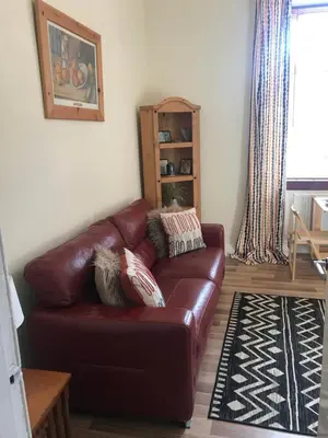 a brown leather couch in a living room at Hillview, Ground floor apartment, Largs in Largs