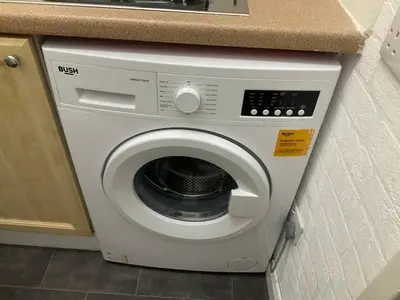 a white washing machine under a counter in a kitchen at Hillview, Ground floor apartment, Largs in Largs