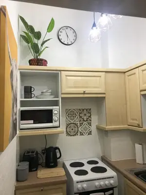 a kitchen with a stove and a clock on the wall at Hillview, Ground floor apartment, Largs in Largs