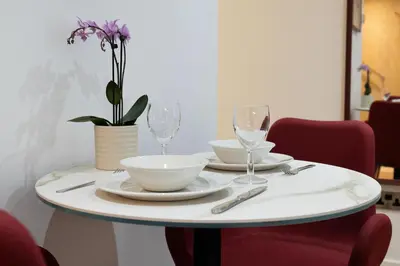 a table with two plates and wine glasses on it at PREMIER SUITES Edinburgh Fountain Court in Edinburgh