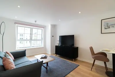 a living room with a couch and a tv at PREMIER SUITES Edinburgh Fountain Court in Edinburgh