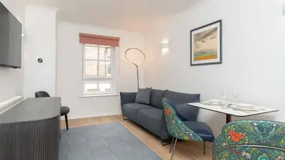 a living room with a couch and a table at PREMIER SUITES Edinburgh Fountain Court in Edinburgh