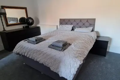 a bedroom with a large bed with towels on it at Large 4 bed (sleeps 8) Castle View in Edinburgh