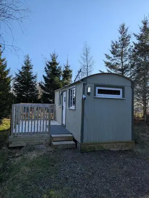 a small shed with a door and a gate at Blair snug hut in Kelty